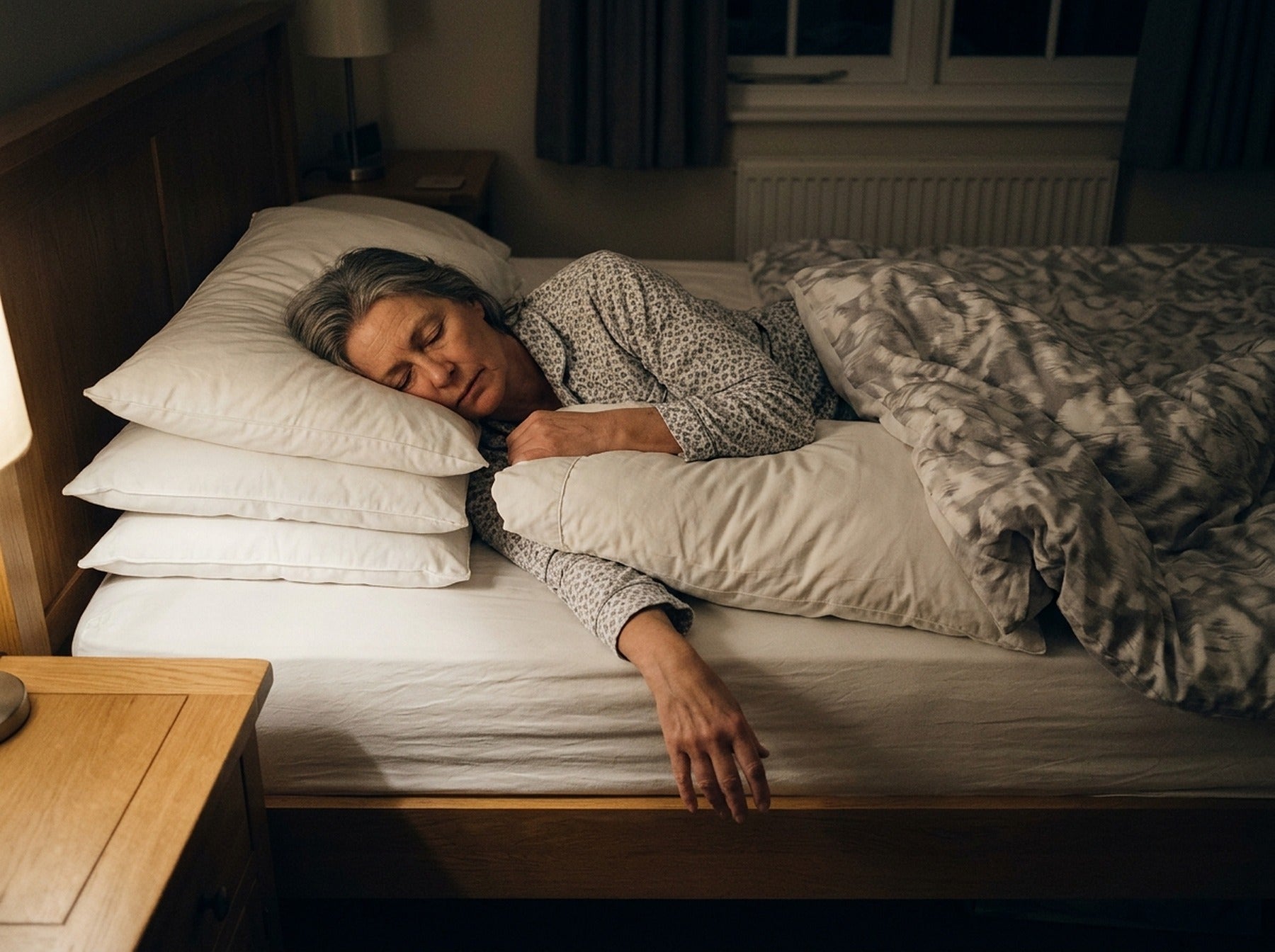 Overhead shot of a bed with four pillows and an arm hanging off the edge