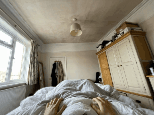 Point-of-view loop of the bedroom tilting as she sits up